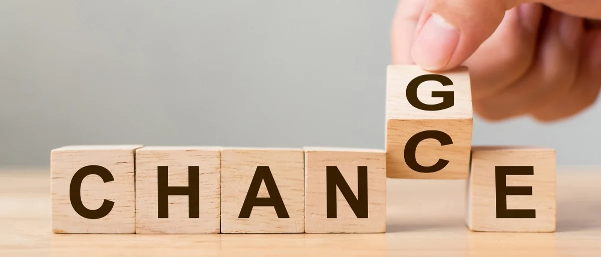 Holzbausteine mit Buchstaben bilden das Wort Change und Chance und stehen sinnbildlich dafür, dass erfolgreicher Wandel weitergetragen werden kann