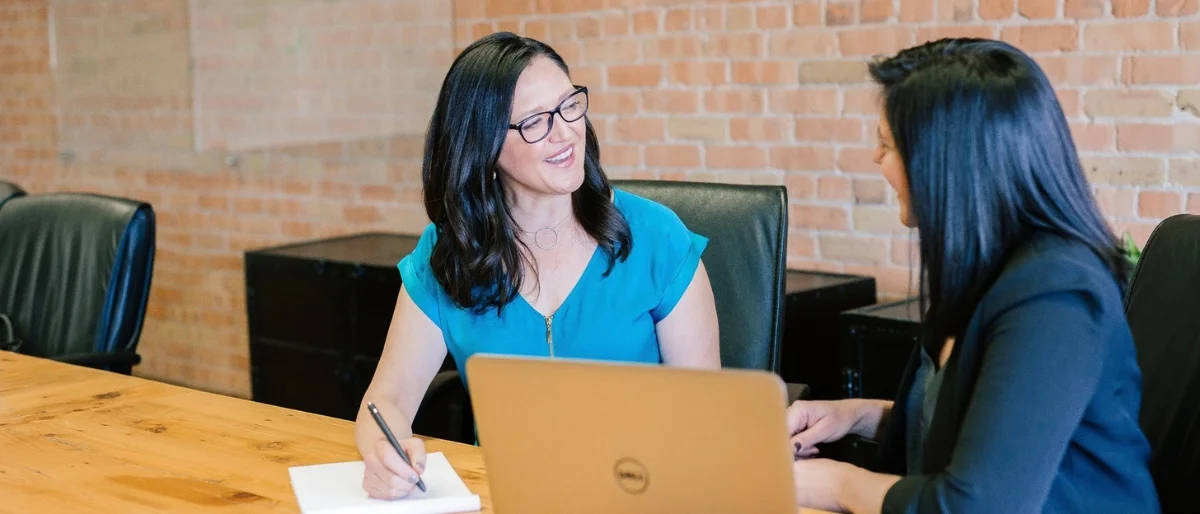 Zwei Frauen im Arbeitskontext geben sich gegenseitig vorwärtsgewandtes Feedforward anstatt Feedback