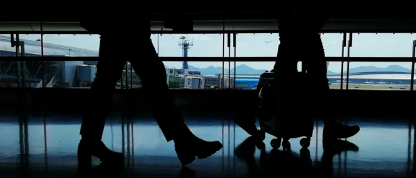 Auf dem Bild sind die Beine von zwei gehenden Personen an einem Flughafen zu sehen. Das Bild steht symbolisch für das Führungskräfte Onboarding bei Carpe Verba!.