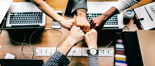 5 Fäuste berühren sich als Symbol für Onboarding Führungskraft im Team