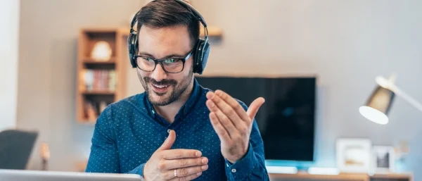 Eine Führungskraft vor dem Bildschirm in Kontakt mit Mitarbeitenden verdeutlicht, dass auch hybride Führung gelingen kann