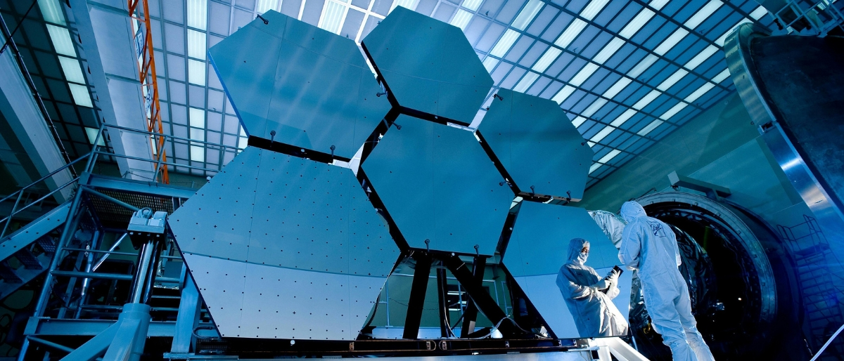 Ein Forscher steht vor einem innovativen Produkt der Raumfahrt, das Bild zeigt wie wichtig Innovation im Kontext Transformation ist