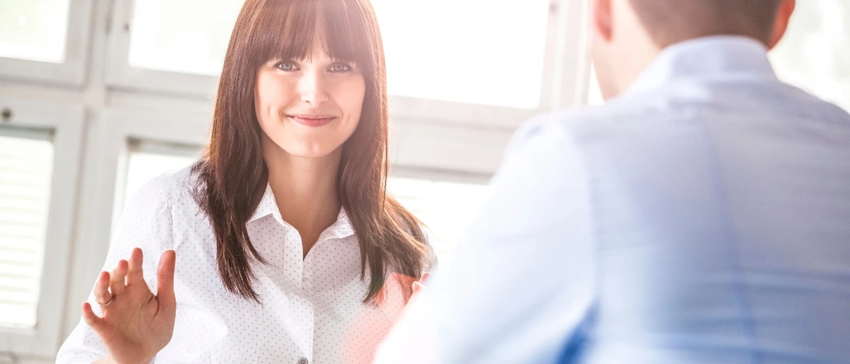 Ein Mann und eine Frau in gelassenem Gespräch strahlen Ruhe und erfolgreiches Konfliktmanagement aus
