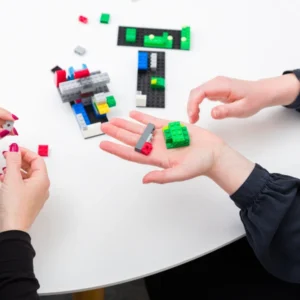 Zwei Personen halten Legosteine in der Hand. Das Bild steht symbolisch für den Workshop "Kreativität und Inspiration für innovative Teams".