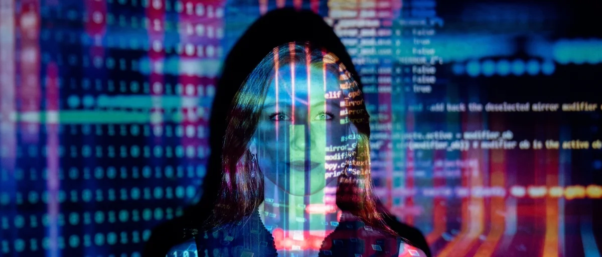 Frau mit Computercode überlagert, steht für das Nutzen von Künstlicher Intelligenz am Arbeitsplatz.
