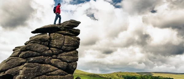 Mann auf einer Klippe steht für Stärke von Resilienz in Zeiten der Transformation, denen im Learning Nugget begegnet werden kann.
