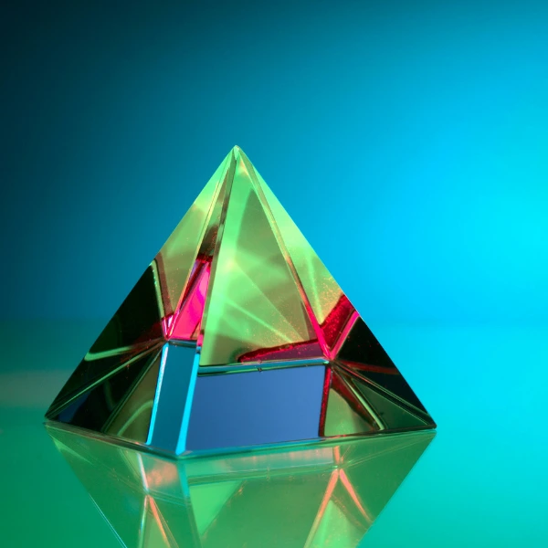 Eine bunte Pyramide steht vor einem blauen Hintergrund. Dies steht symbolisch für pyramidale Kommunikation.