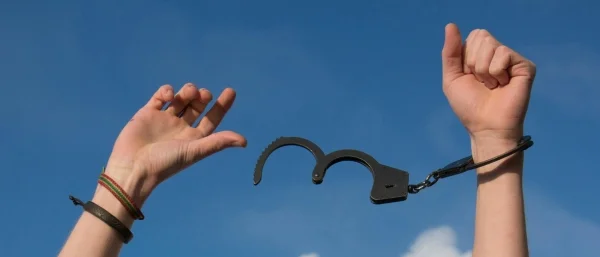 Hände machen sich frei von Fesseln, ein ähnliches Gefühl zeigt sich bei hoher Resilienz im Wandel
