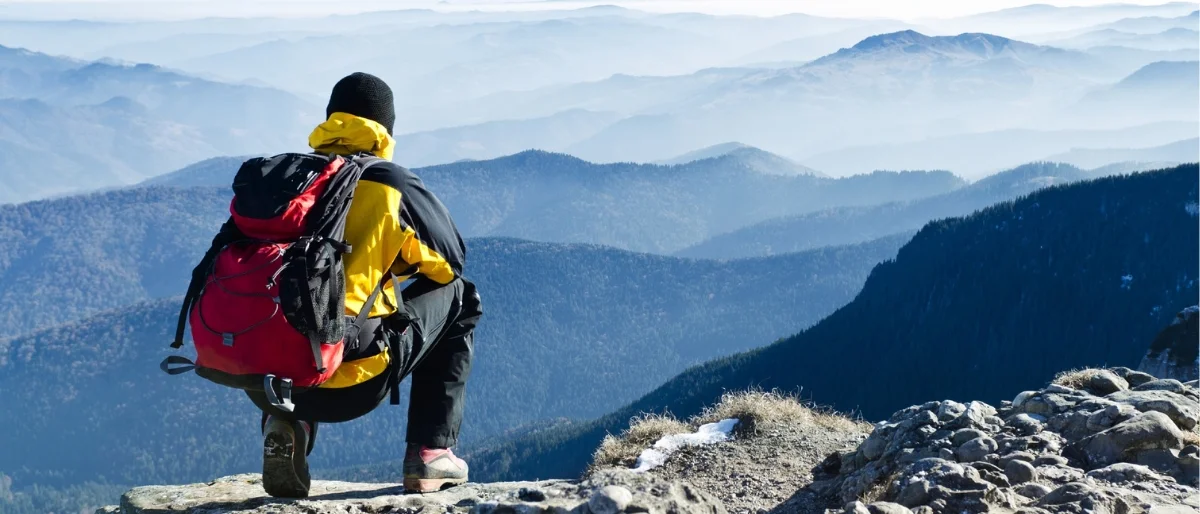 Wanderer blickt in die Berge – Symbol für Resilienz, mentale Stärke, Stressbewältigung und persönliche Widerstandsfähigkeit im Alltag.