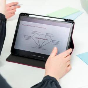 Auf dem Bild sieht man ein Tablet mit einer offenen Folie zum Thema "Rollenkompetenz".