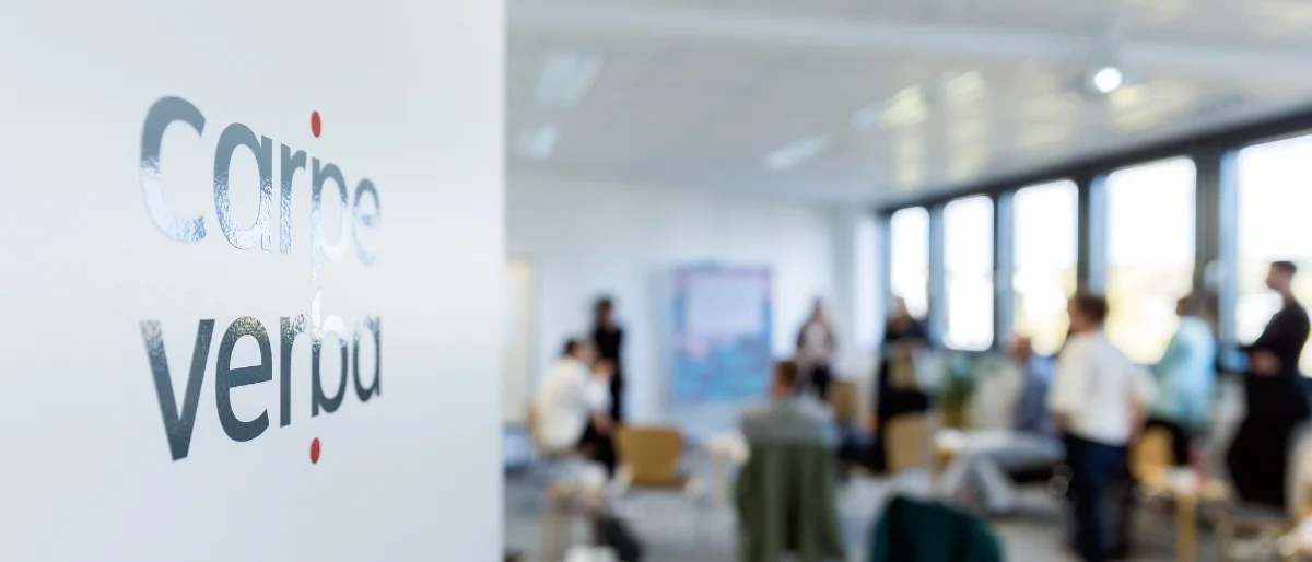 Geöffnete Tür mit Carpe verba!-Logo und Workshop im Hintergrund