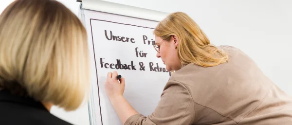 Bettina Golba - Trainerin von Carpe Verba - schreibt auf einen Flipchart zum Thema "Feedback wirkungsvoll - Let's Feedforward".