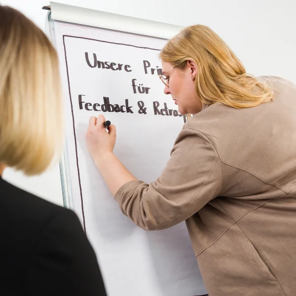 Bettina Golba - Trainerin von Carpe Verba - schreibt auf einen Flipchart zum Thema "Feedback wirkungsvoll - Let's Feedforward".
