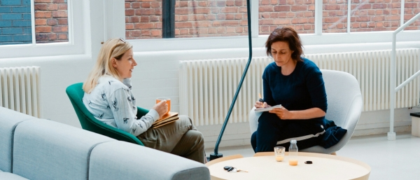 Zwei Personen im Coaching-Gespräch in einem modernen Raum – symbolisiert persönliche Entwicklung, Coaching-Methoden und effektive Gesprächsführung.