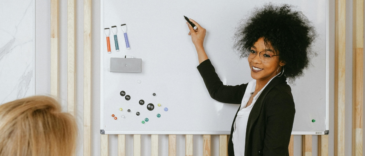Coach erklärt eine Methode an einem Whiteboard – Symbol für Coaching, kreative Problemlösungen, persönliche Entwicklung und effektive Kommunikation.