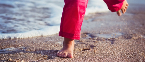 Kinderfüße am Strand als Symbol für persönliches Wachstum