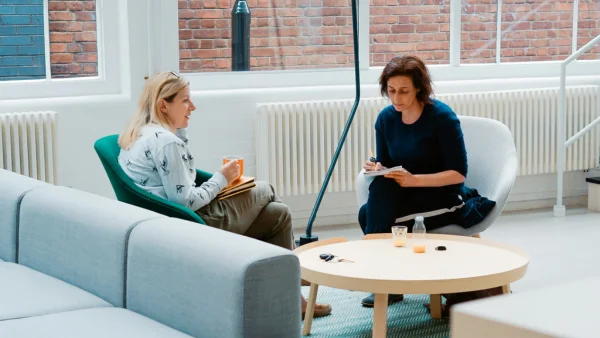 2 Frauen sitzen gemeinesam im Coaching an einem Tisch